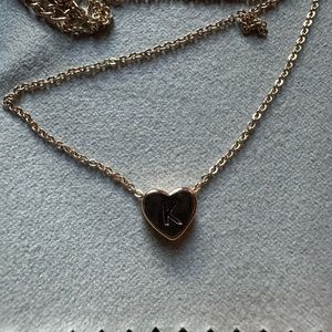 gold bracelet with a heart that has a k on it